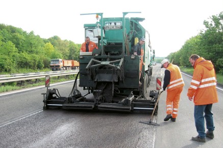 Les machines de mélange et de pose répandent le mélange pour la fine couche froide sur la surface finement broyée avec des chapes Vario.