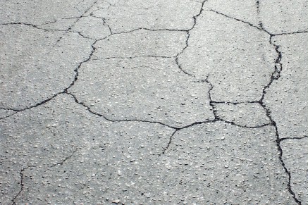 La couche de surface doit être réhabilitée en raison de fissures sévères dans la chaussée.