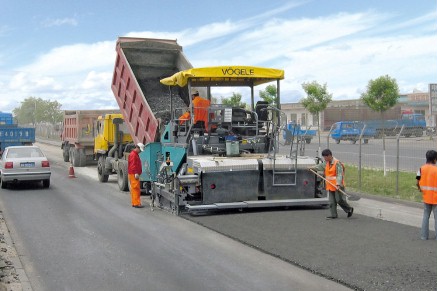  Le finisseur VÖGELE disposant une nouvelle couche de surface.